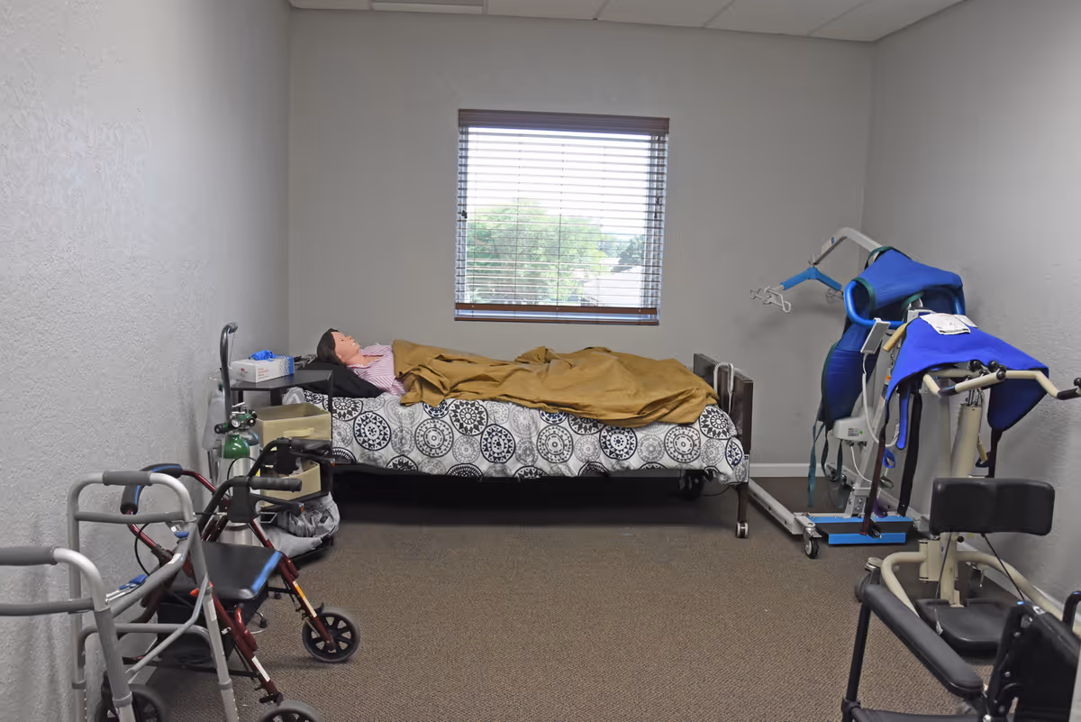 A small care bedroom with a bed, window, and medical equipment.