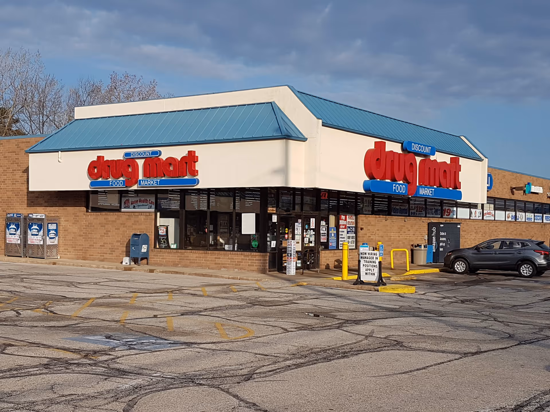 Discount Drug Mart storefront with blue roof and car in parking lot.