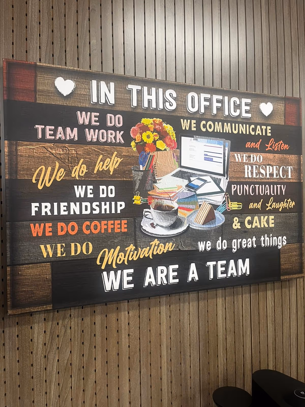 Large wooden signboard on a wall with motivational phrases in an office interior.