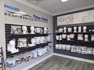 Interior display area with CPAP masks and accessories on wall shelves.