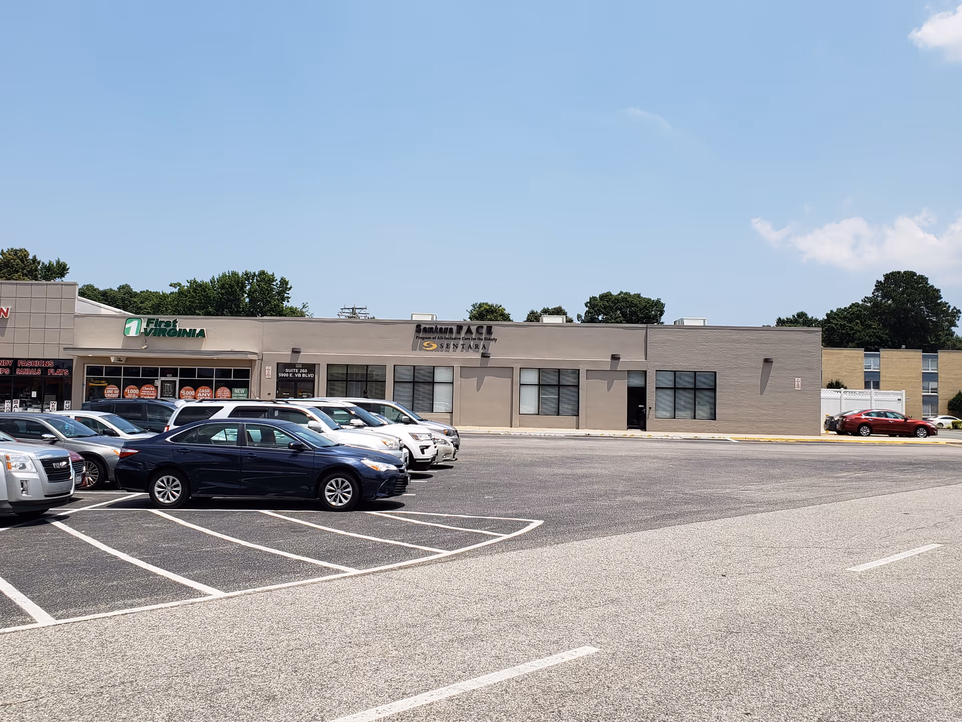 Exterior view of a Sentara PACE building with a parking lot in front.