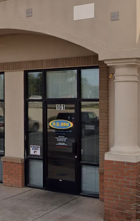 Exterior view of a facility entrance with glass doors labeled 101 and MD NOW sign.