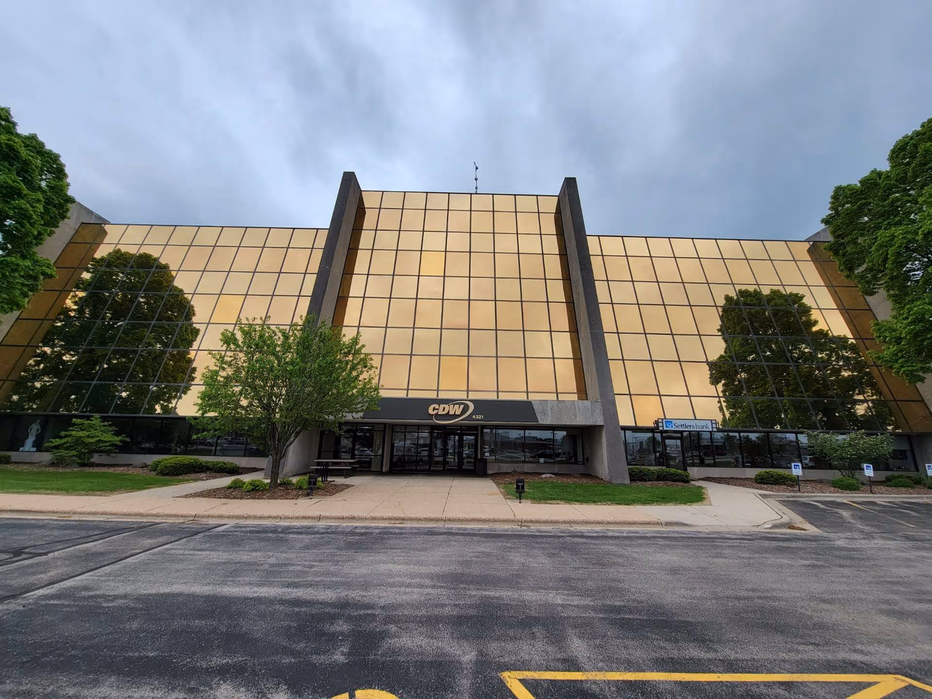 A large building with a gold-tinted glass facade and a central entrance.