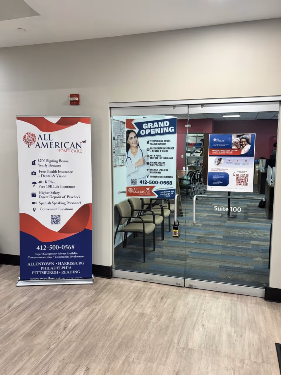 Glass doors to a lobby with promotional banners advertising All American Home Care.