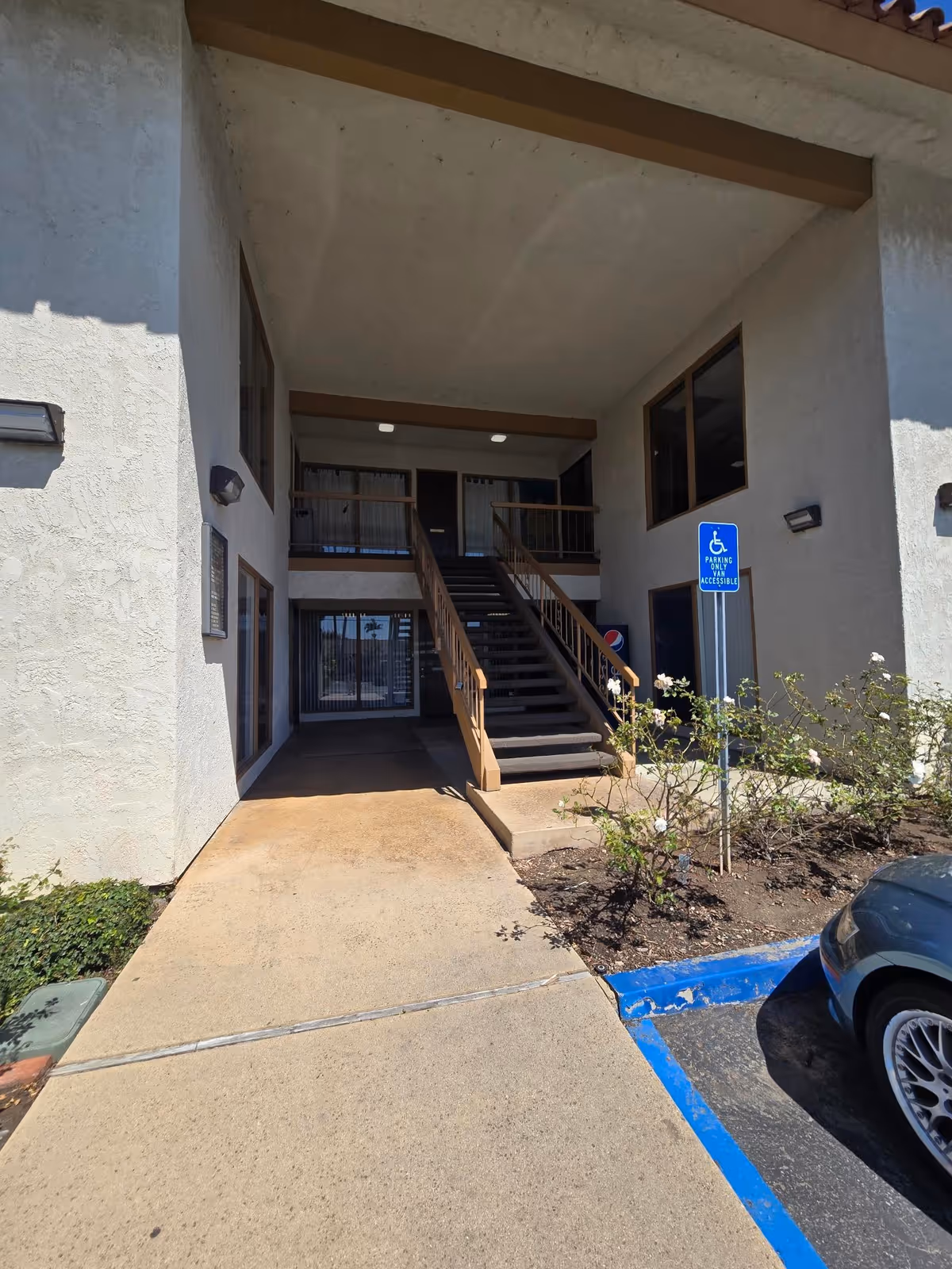 Exterior view of Homewatch CareGivers Huntington Newport Beach entrance with stairs and parking