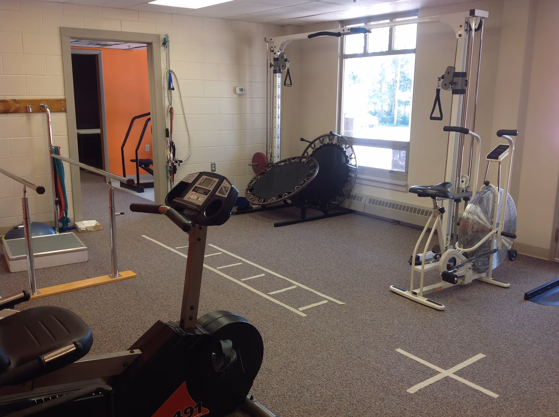 Interior exercise room with stationary bikes, a treadmill, and workout equipment.
