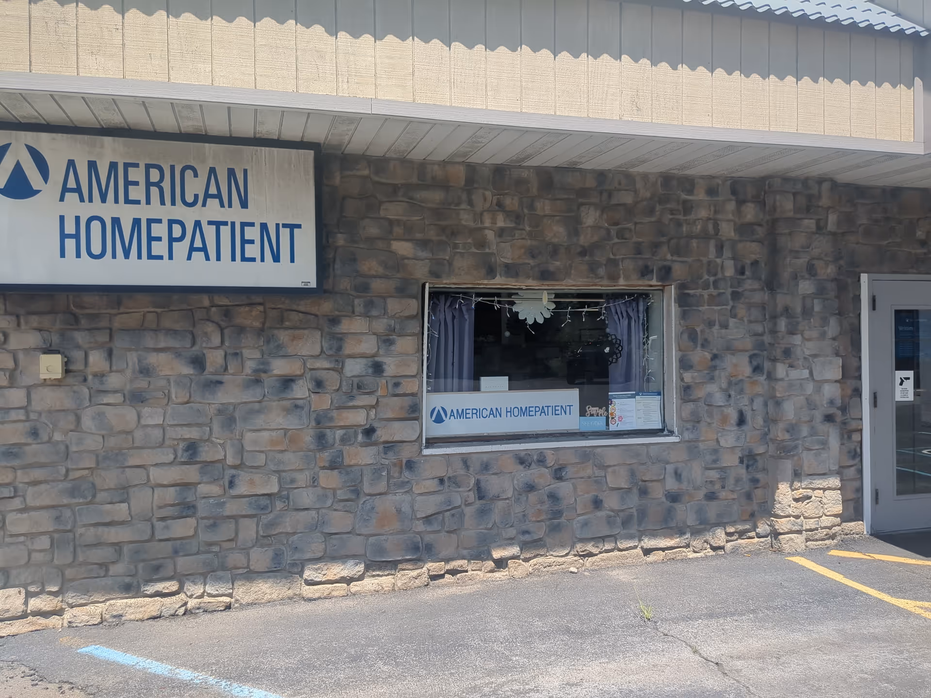 Stone facade with American HomePatient sign and front window near the entrance