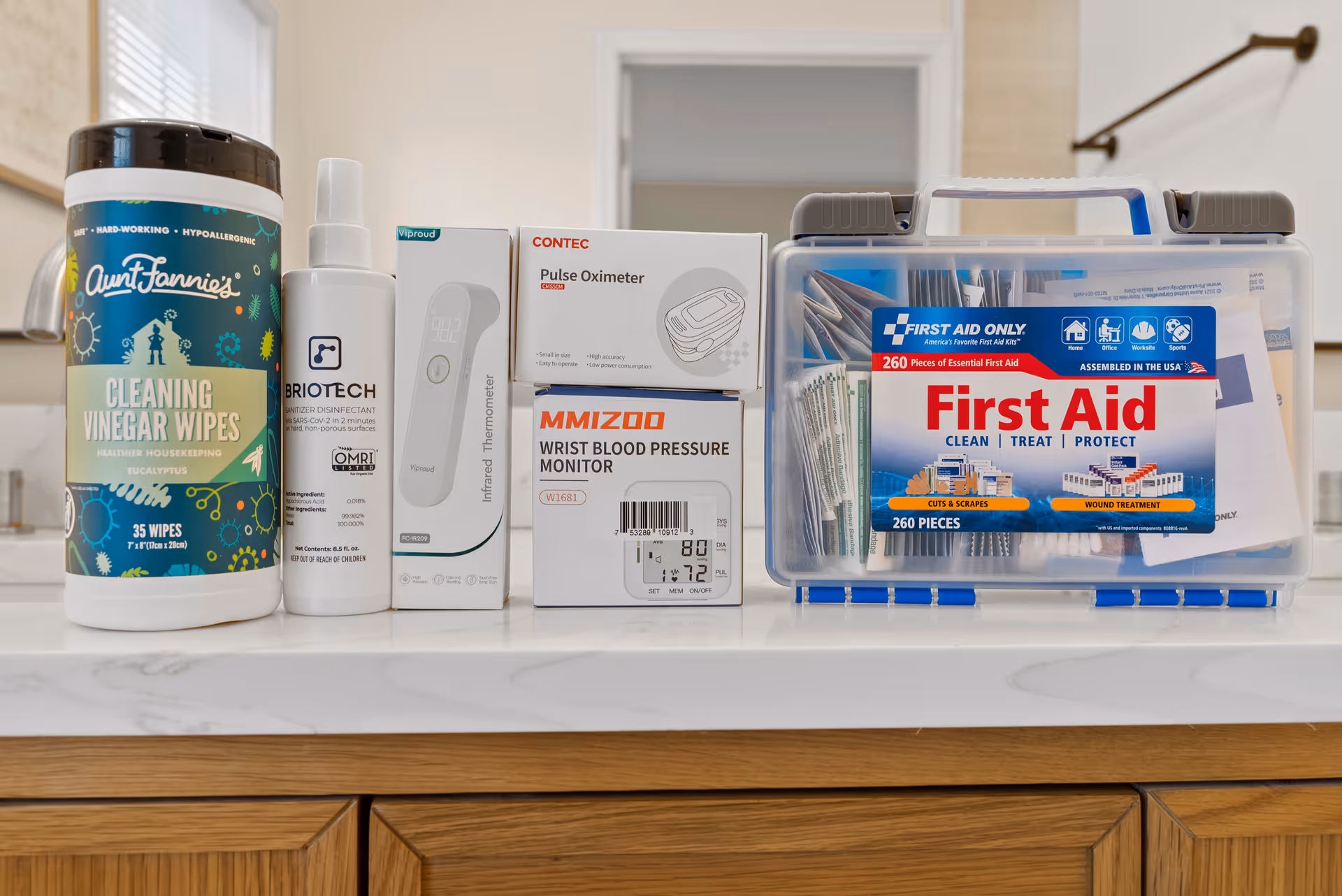 Assorted medical supplies and a first aid kit neatly arranged on a kitchen counter.