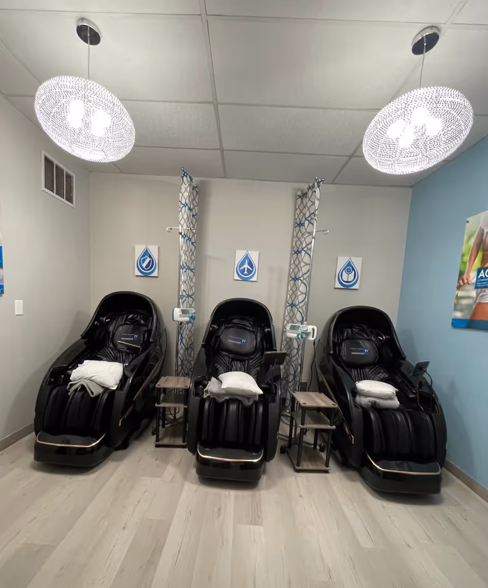 Three black reclining spa chairs with pillows in a clean, well-lit treatment room.