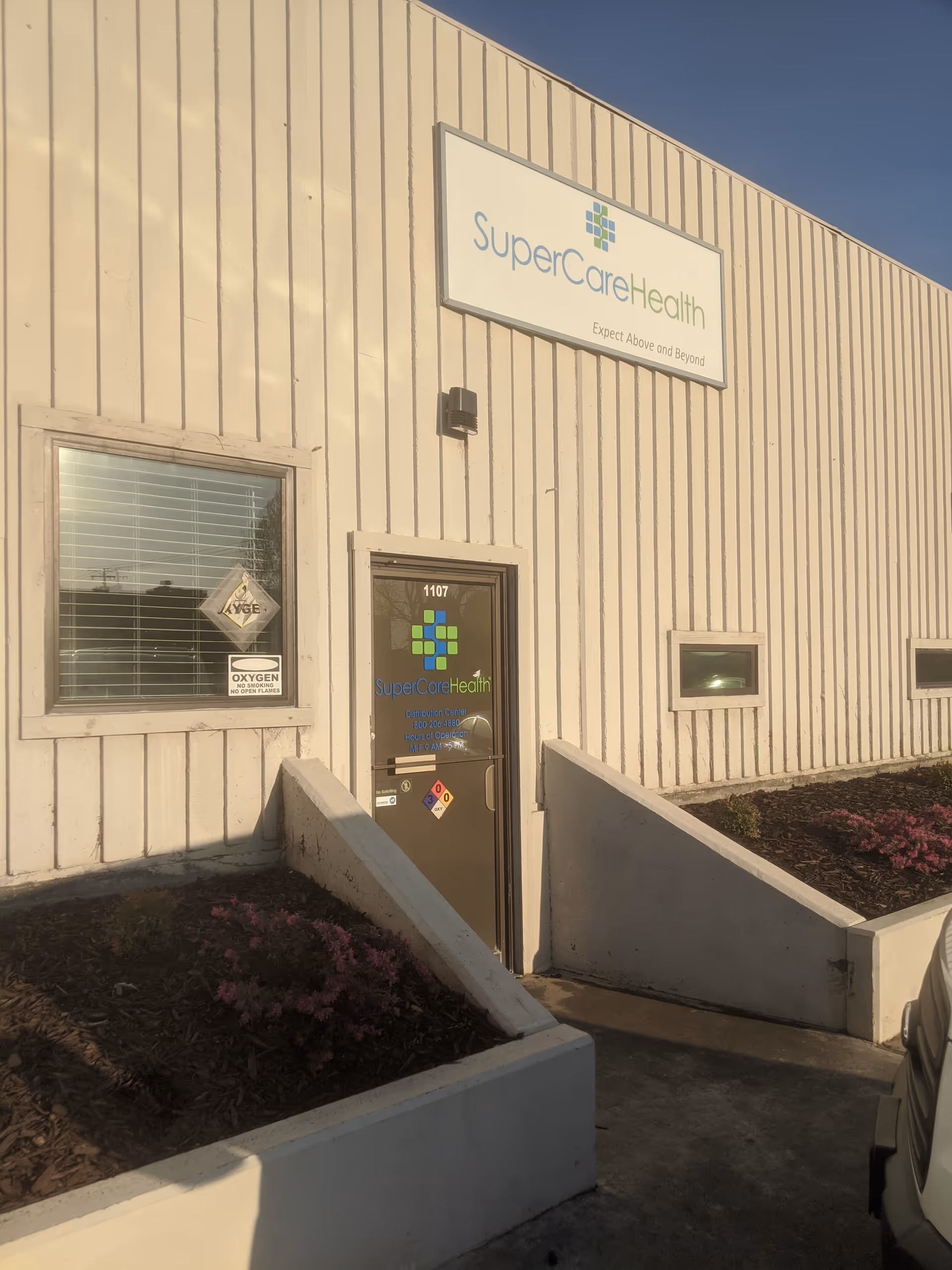 Exterior view of a SuperCare Health facility with sign and entrance.