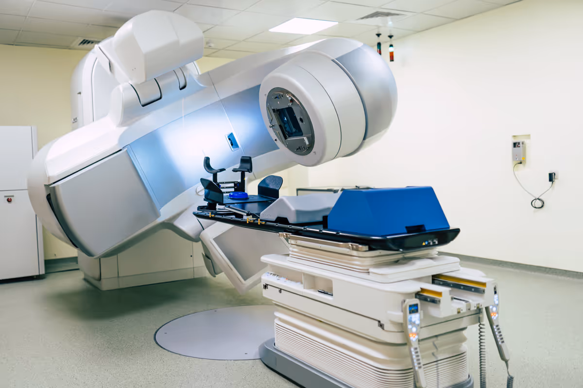 A large CT scanner dominates a medical imaging room with a patient table.