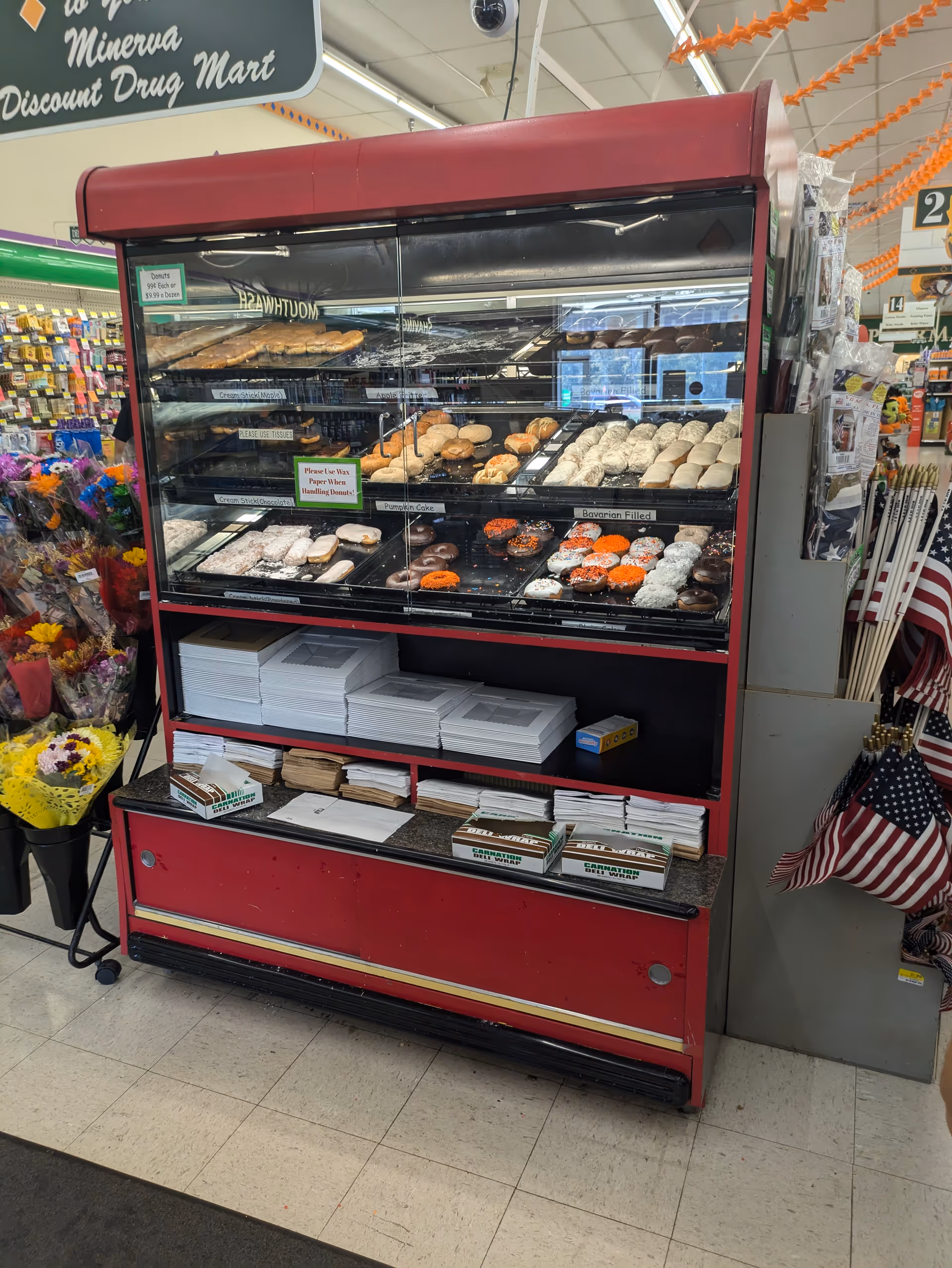 Discount Drug Mart bakery display case with donuts and pastries inside a store.