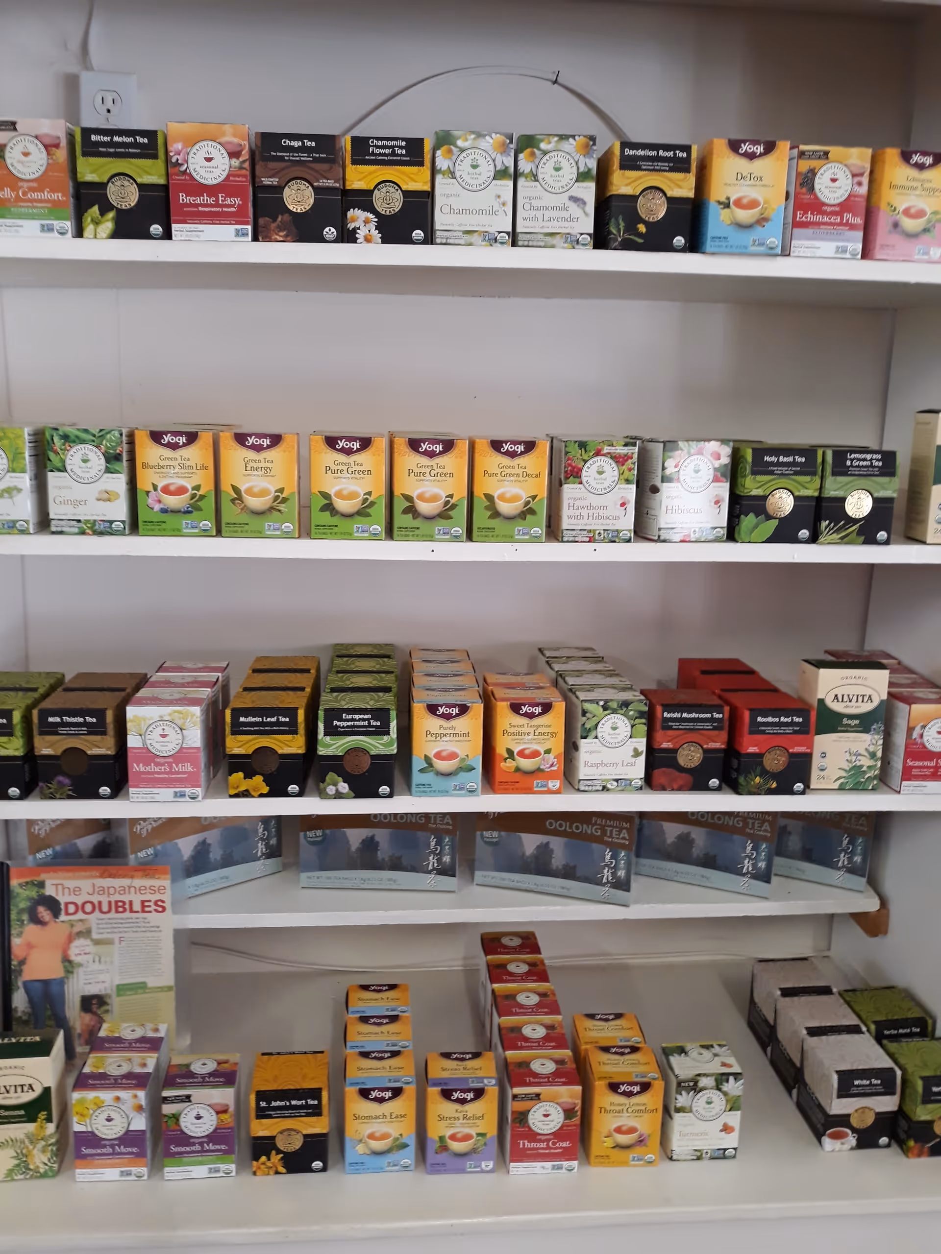 Shelves stocked with assorted tea boxes line a neat interior display at Healthy Solutions