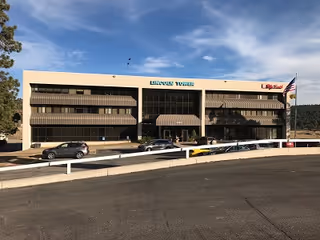 Exterior view of Enhabit Hospice building with a parking lot and blue sky above.