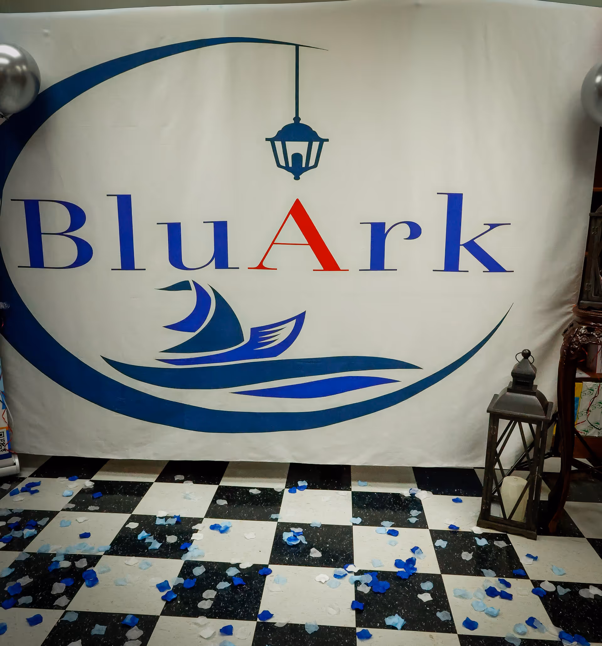A large BluArk banner dominates an indoor space with a checkered floor.