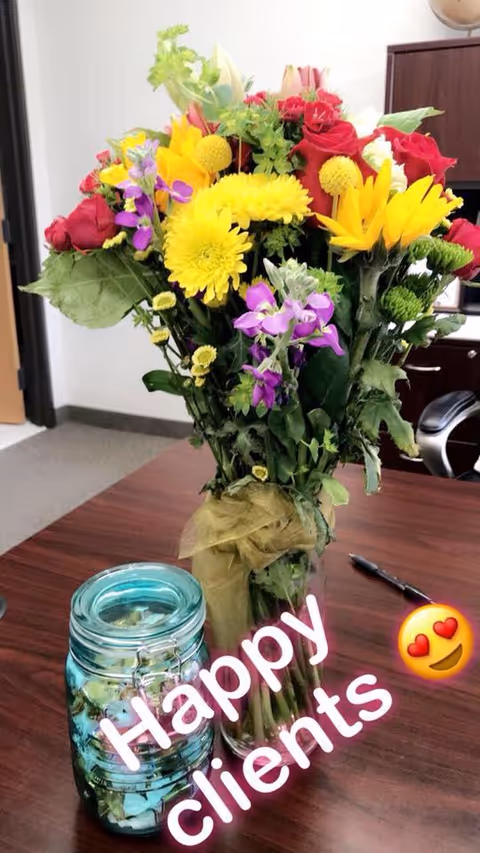 Colorful bouquet on a desk in a small interior office setting.