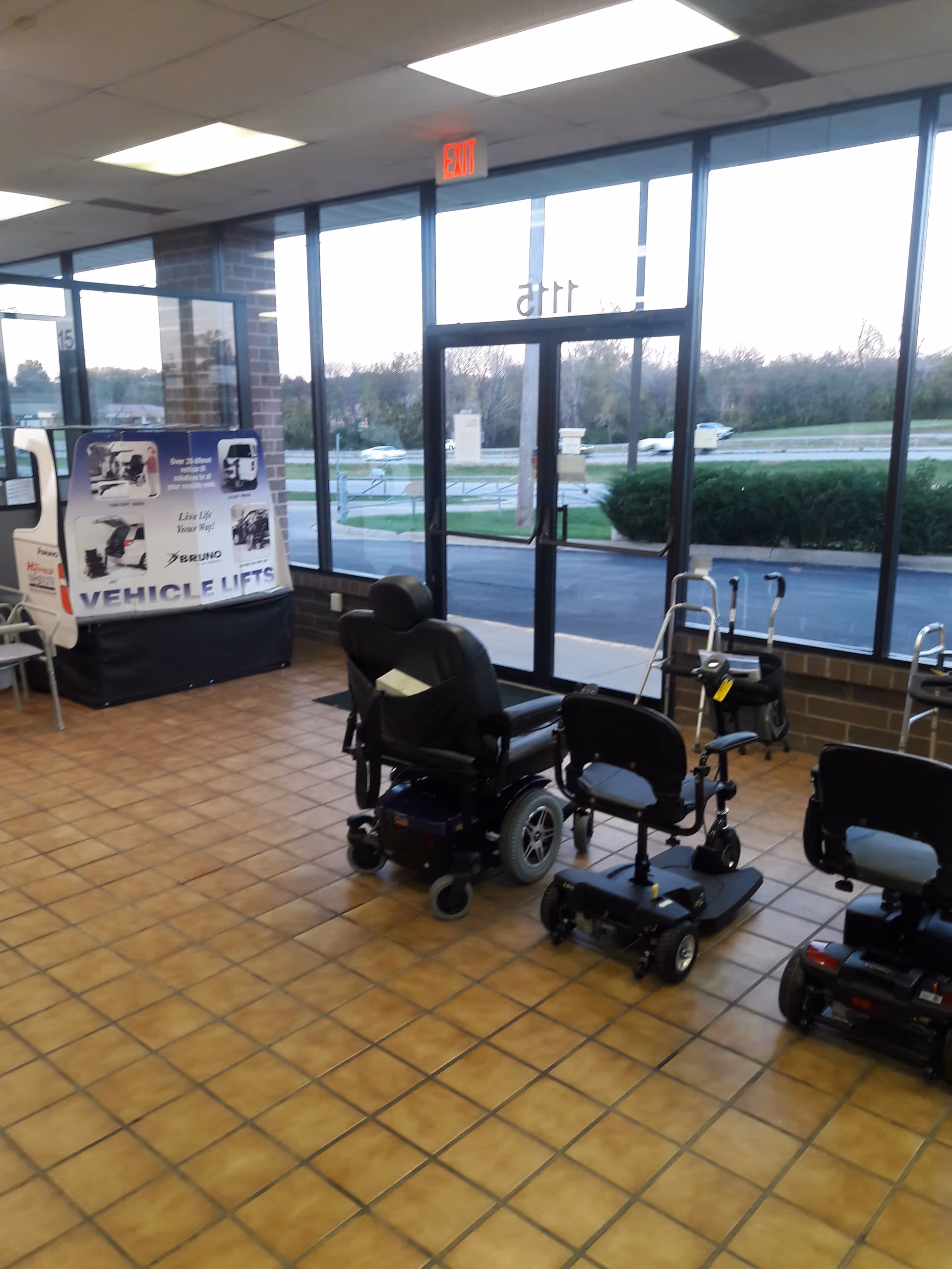 Inside a MobilityWorks showroom, several motorized wheelchairs and mobility scooters on tiled floor.