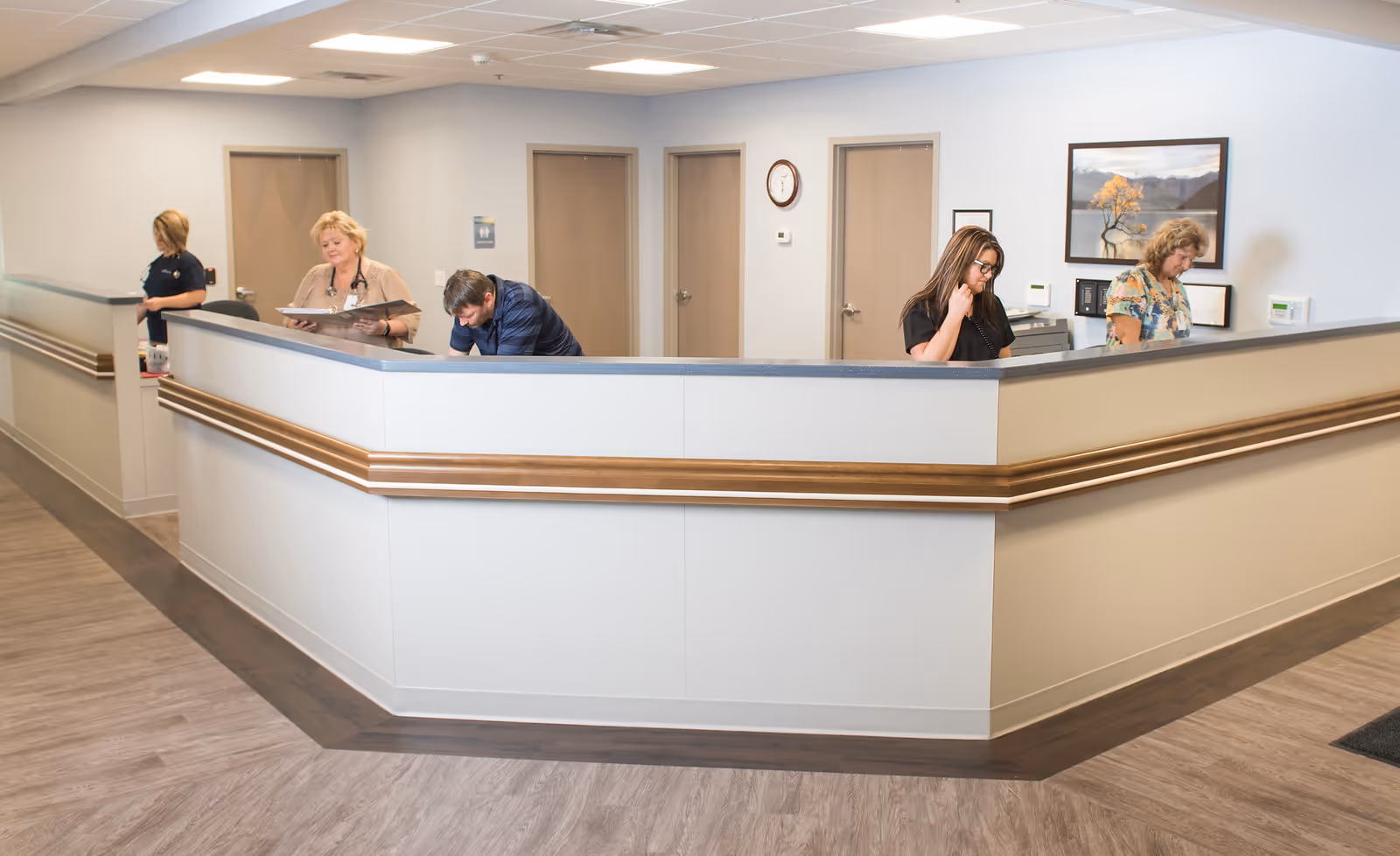 Interior of a senior care facility reception area with staff at a curved desk.