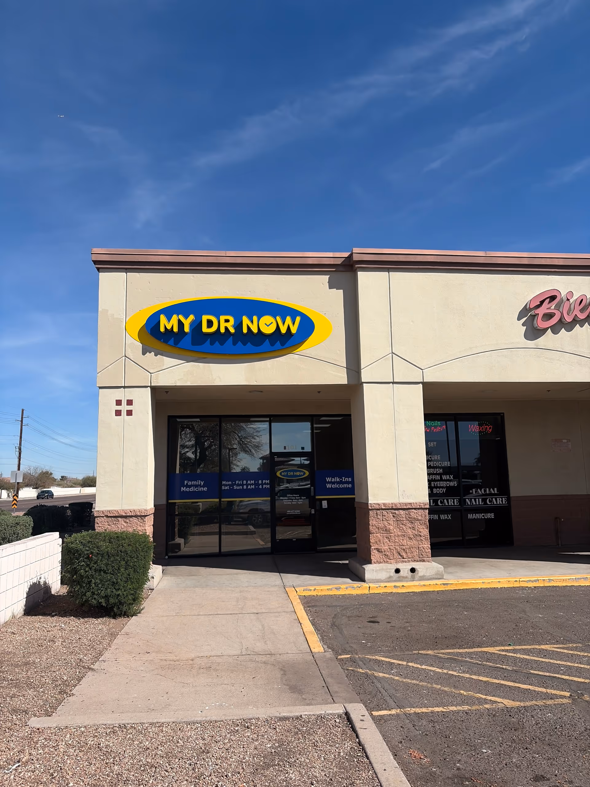 Front of a beige building with MY DR NOW sign above glass doors.
