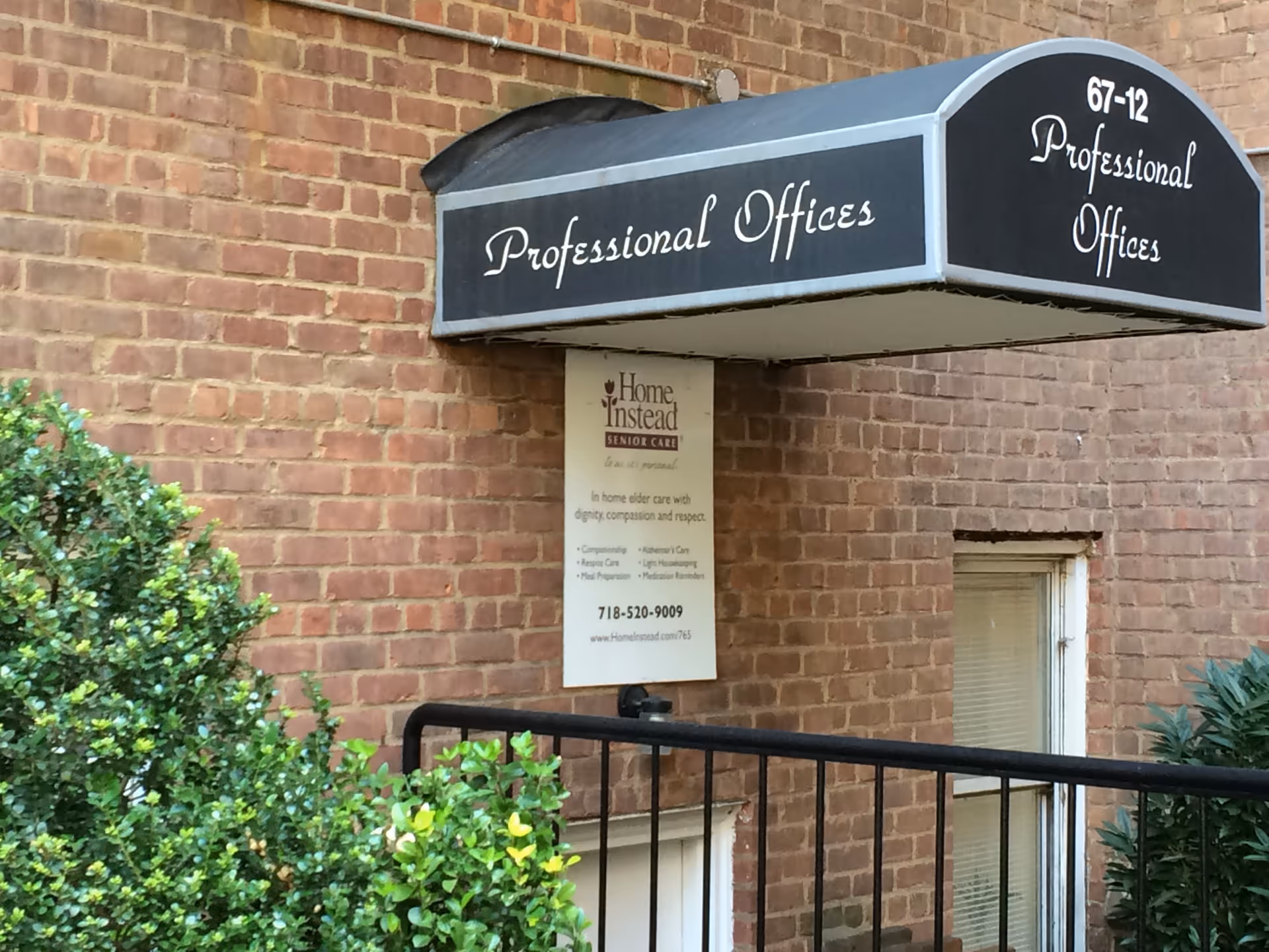 Brick building exterior with a curved canopy reading Professional Offices and Home Instead sign