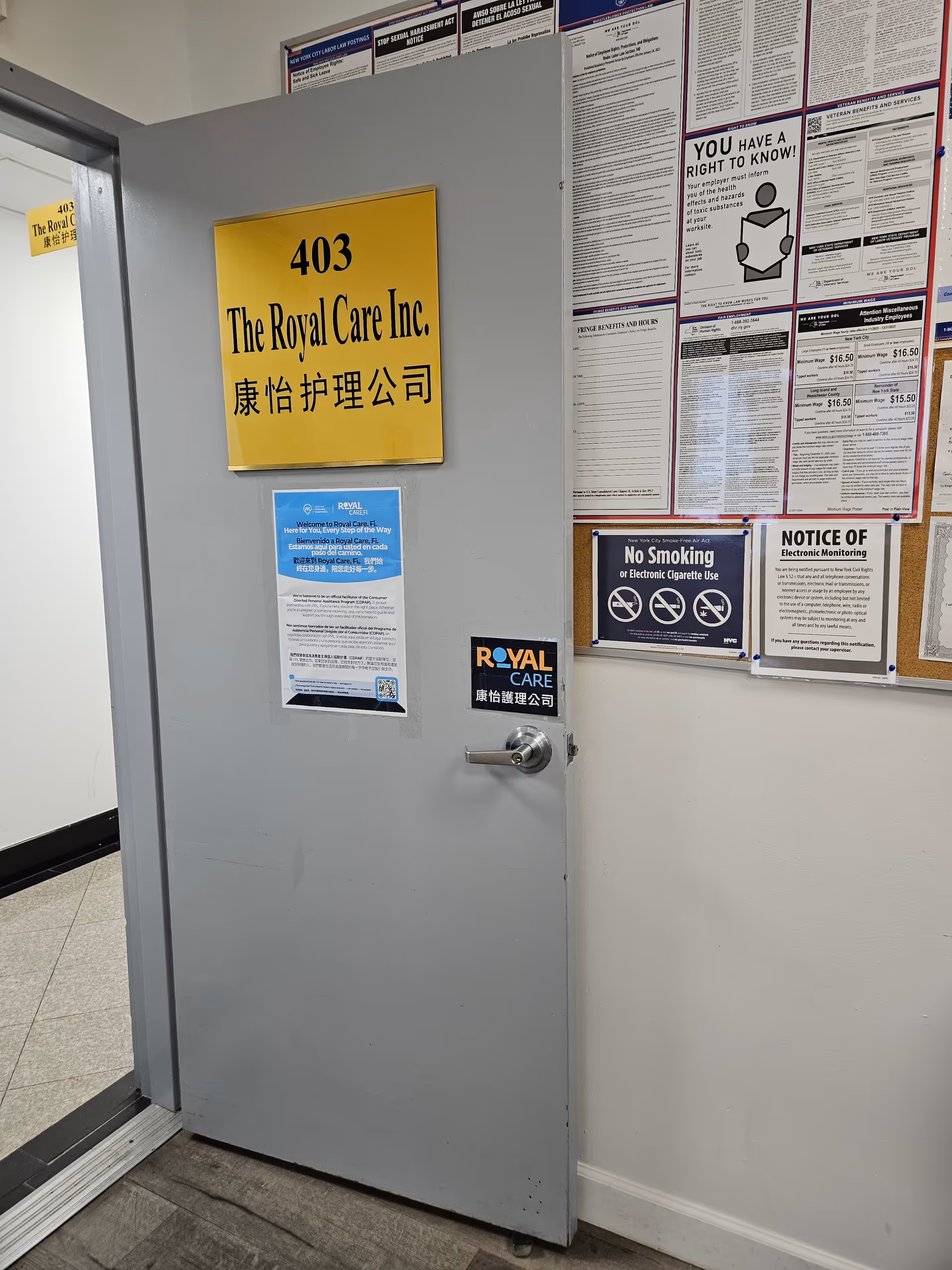 Grey door labeled 403 The Royal Care Inc. with notices on a bulletin board inside.