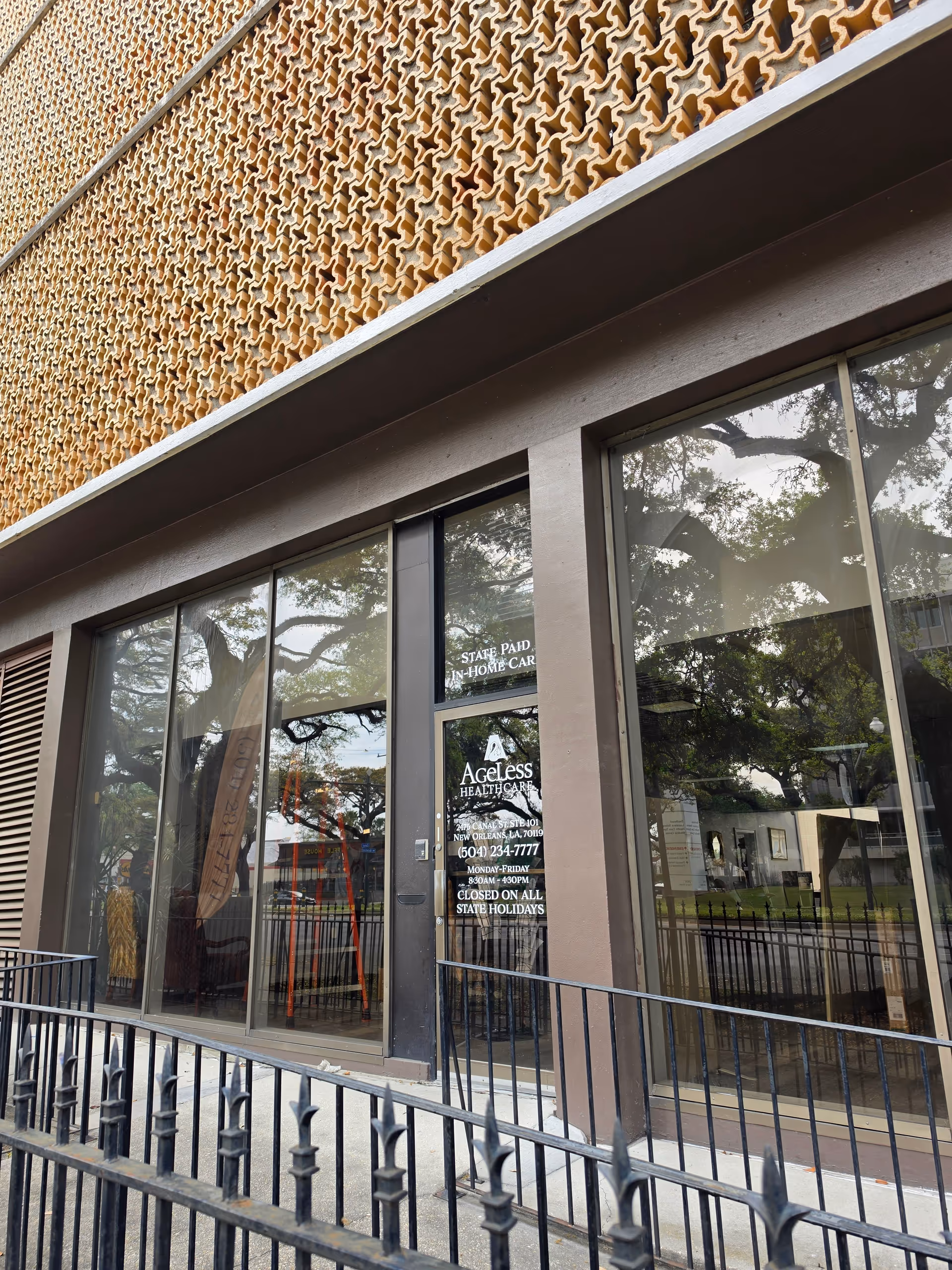 Front exterior of Ageless Healthcare with glass doors, railing, and decorative brick facade.