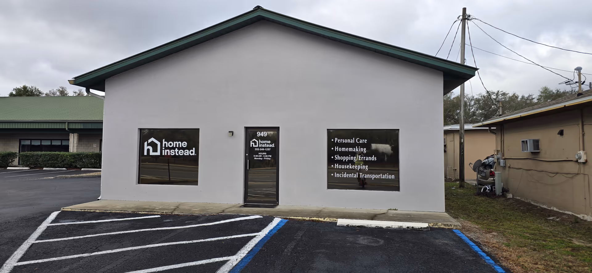 Front view of a small Home Instead facility building with parking and signage.