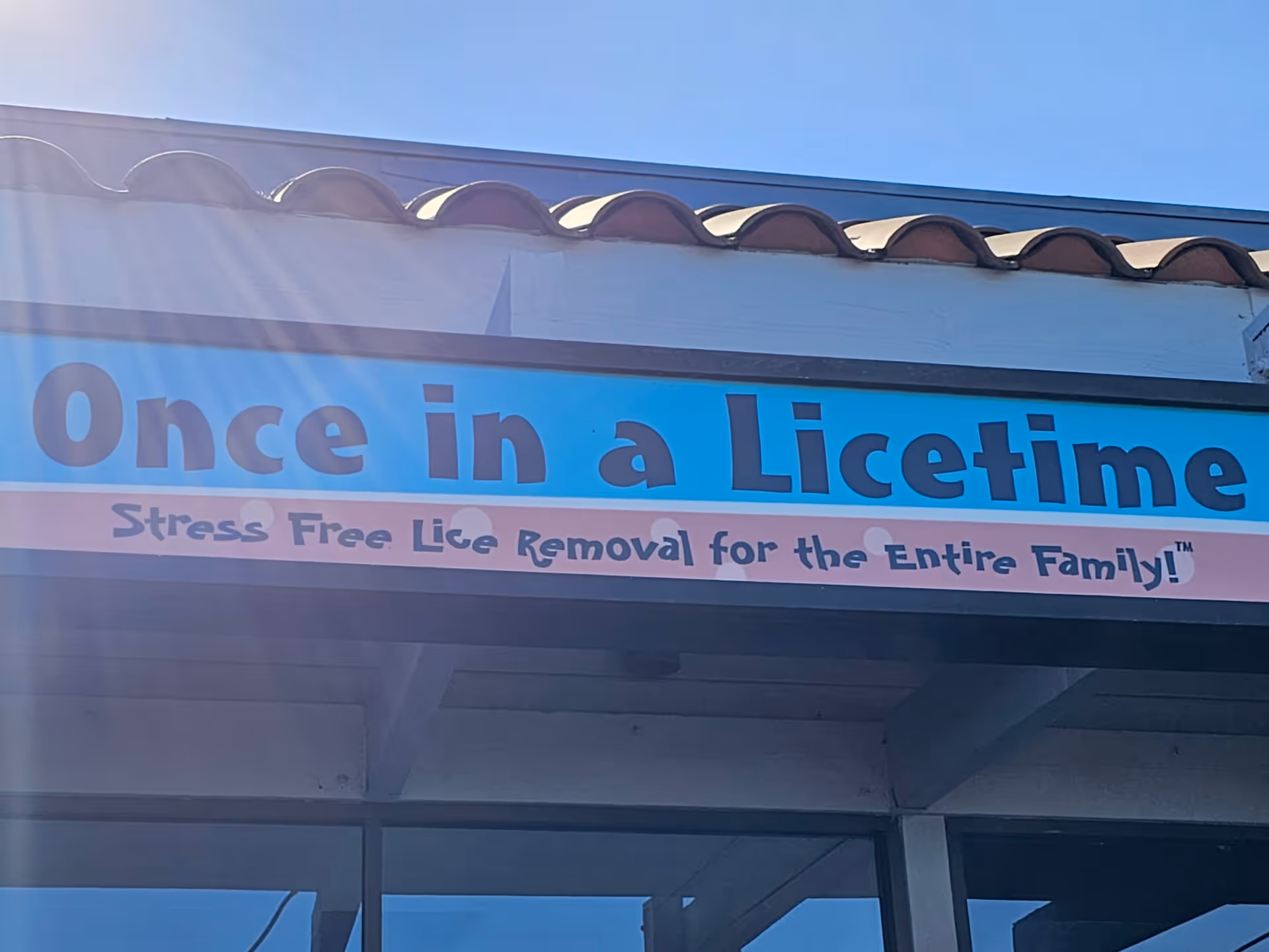 Exterior storefront sign displaying 'Once in a Licetime' outside a building.