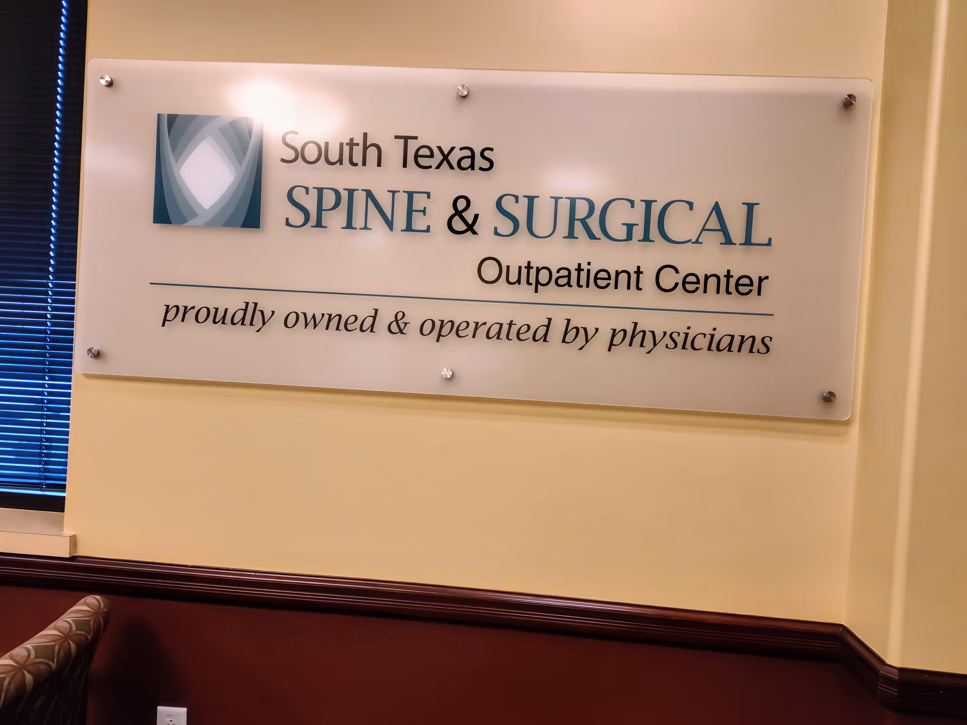 Interior wall sign reading South Texas Spine and Surgical Outpatient Center in a waiting area