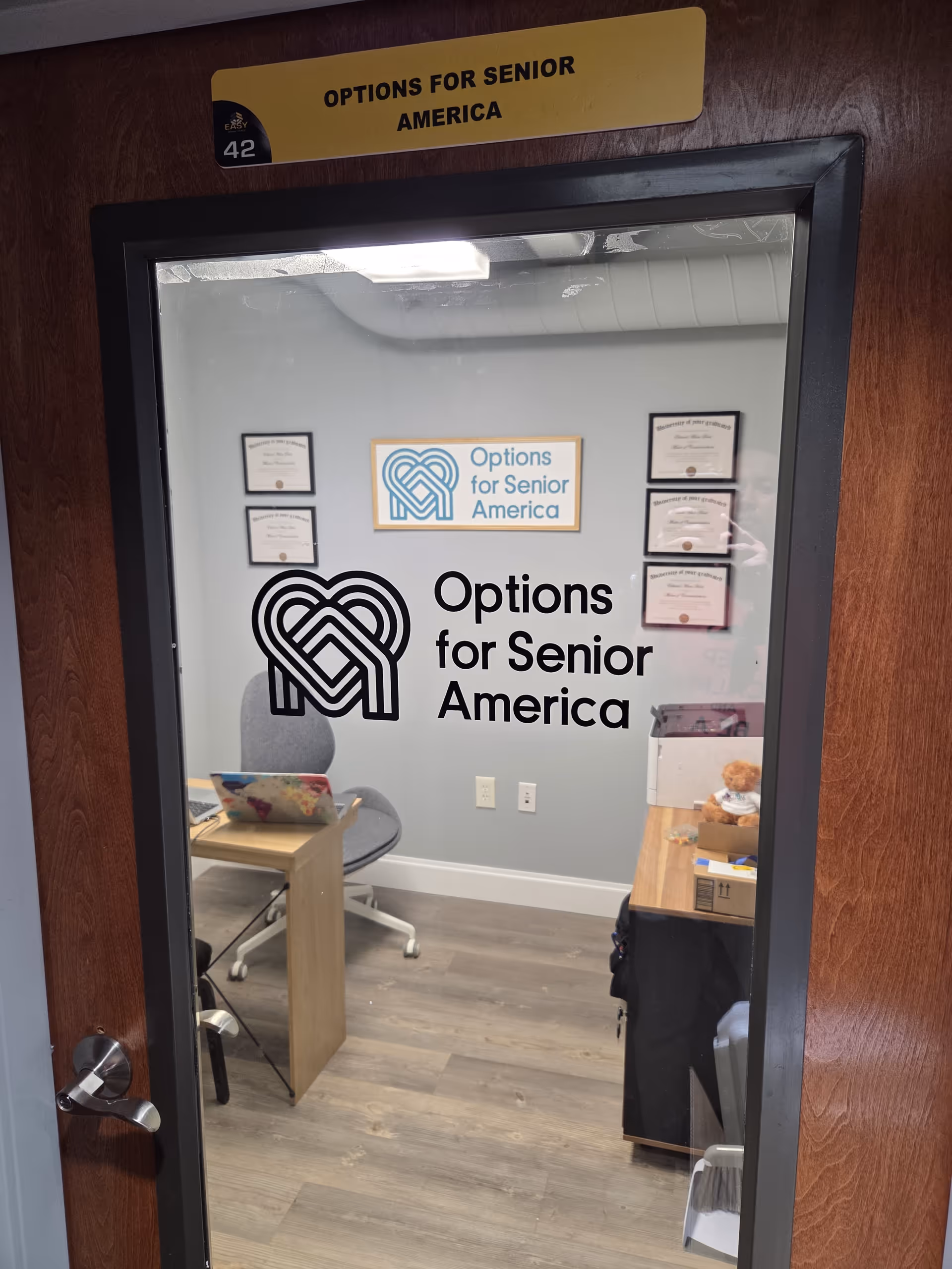 Interior office space with Options for Senior America logo on wall and desk.