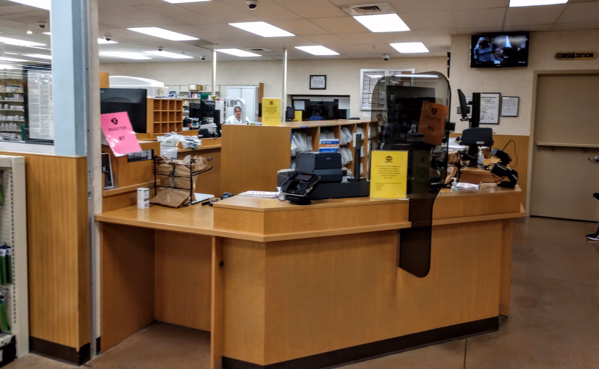 An interior Kroger Pharmacy checkout area features a wooden counter and equipment.