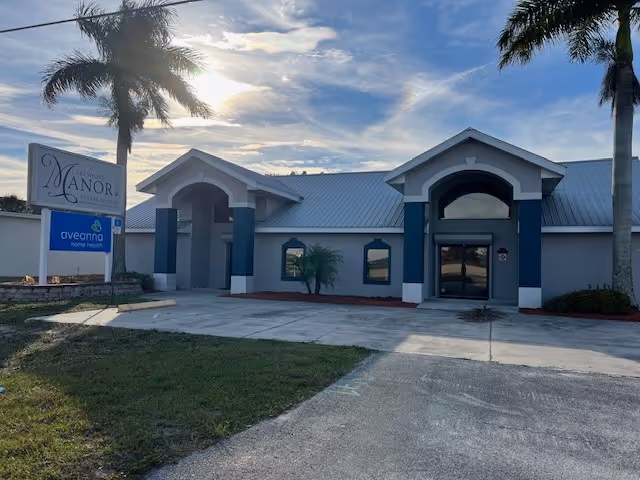 Front exterior of Aveanna Home Health facility, with arched entrances, palm trees, and a sidewalk.