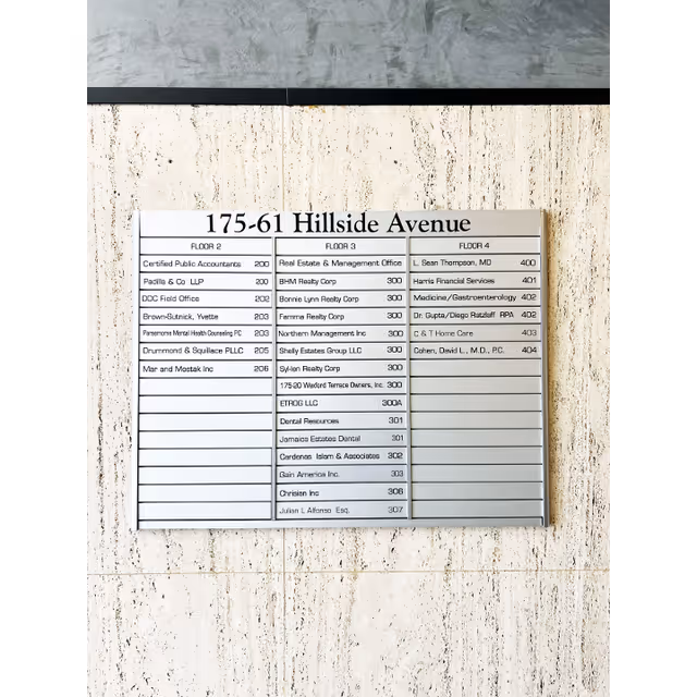 Interior hallway directory sign listing tenants at 175-61 Hillside Avenue
