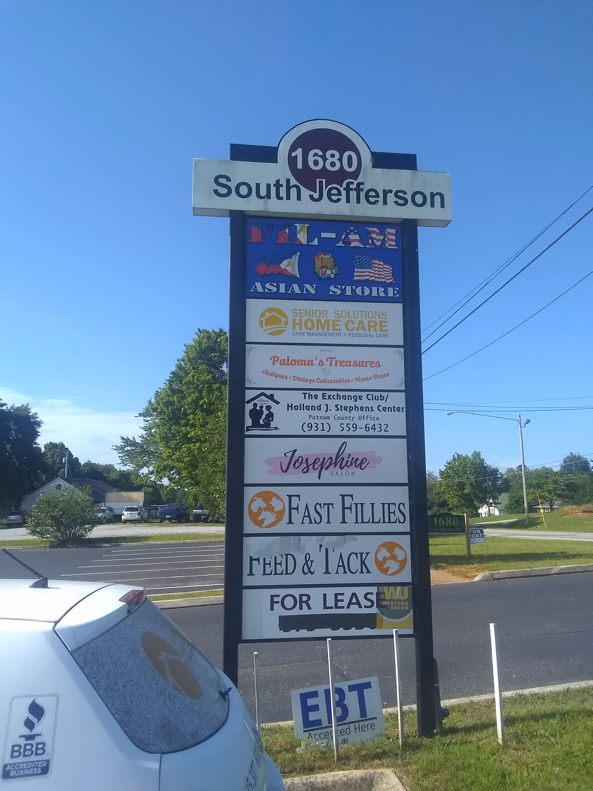 Tall outdoor signboard displaying multiple business ads, including Senior Solutions Home Care.