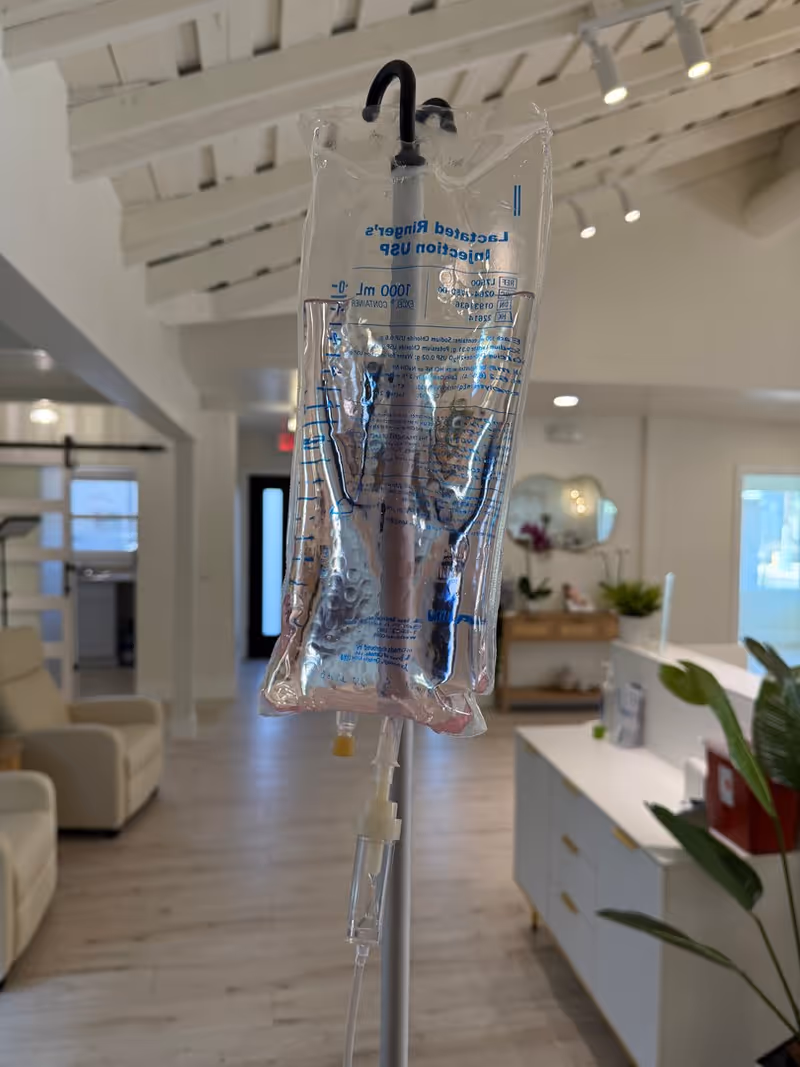 IV bag on stand in a bright senior living lobby interior
