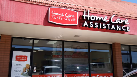 Red storefront with Home Care Assistance signage and large glass windows.