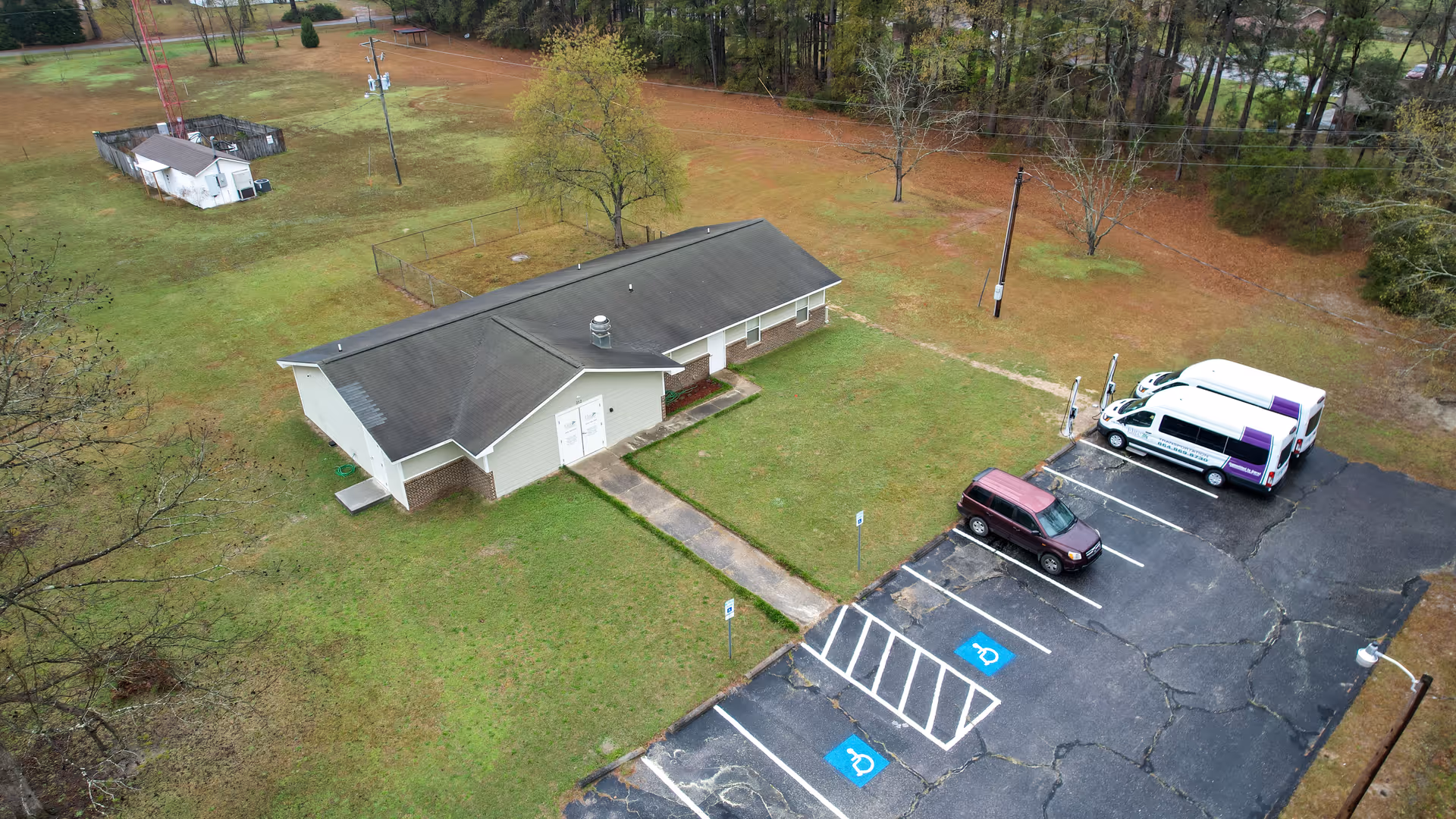Aerial view of a single-story care facility with parking and a shuttle van.