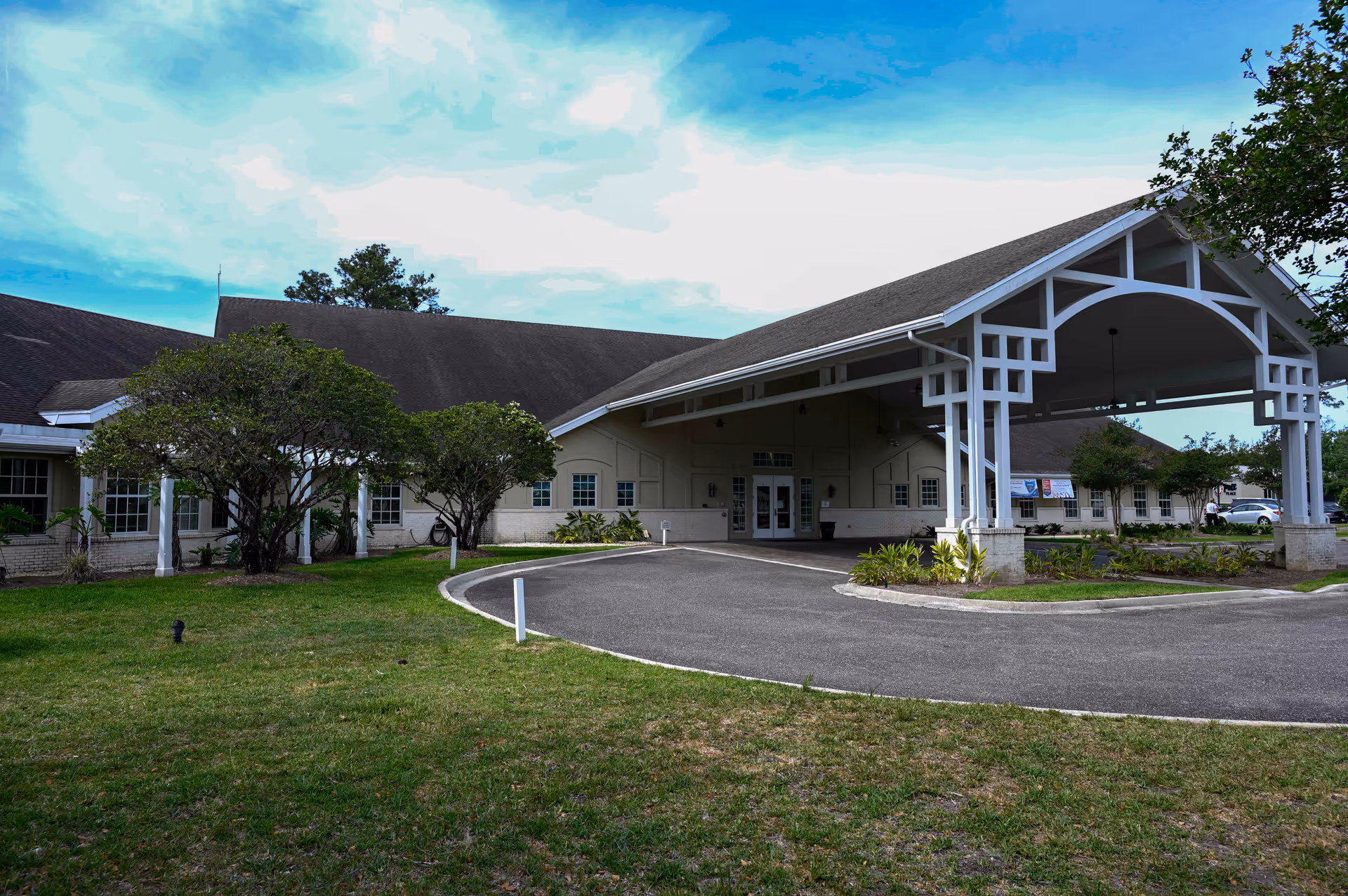 Exterior view of Alivia Care at Home facility with a covered entrance and curved driveway.