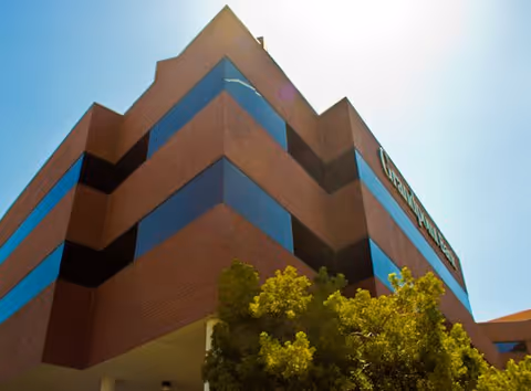 Low-angle view of Care Light Home Care building with brick facade and blue-tinted windows.