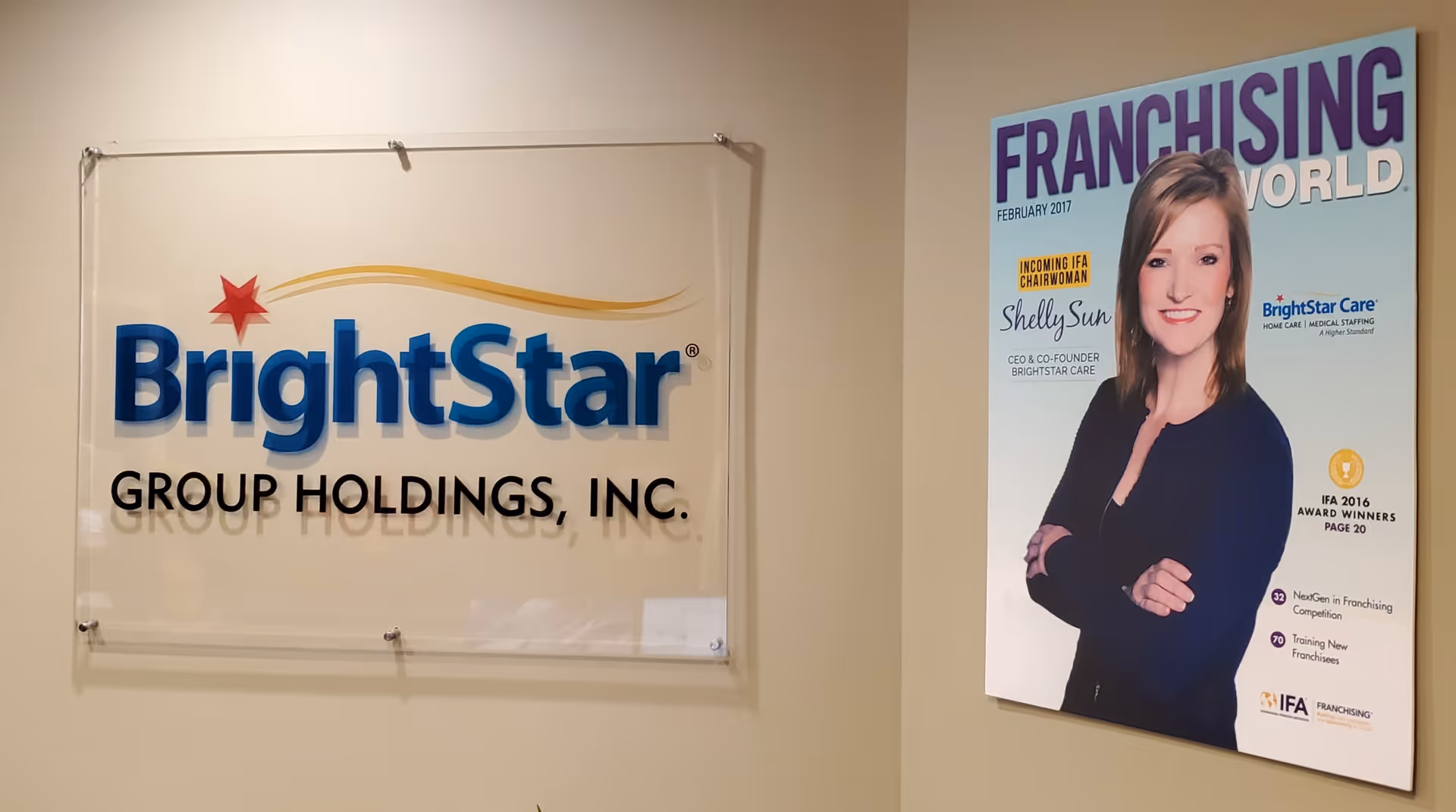 Interior wall displays BrightStar Group Holdings sign beside a Franchising World poster.