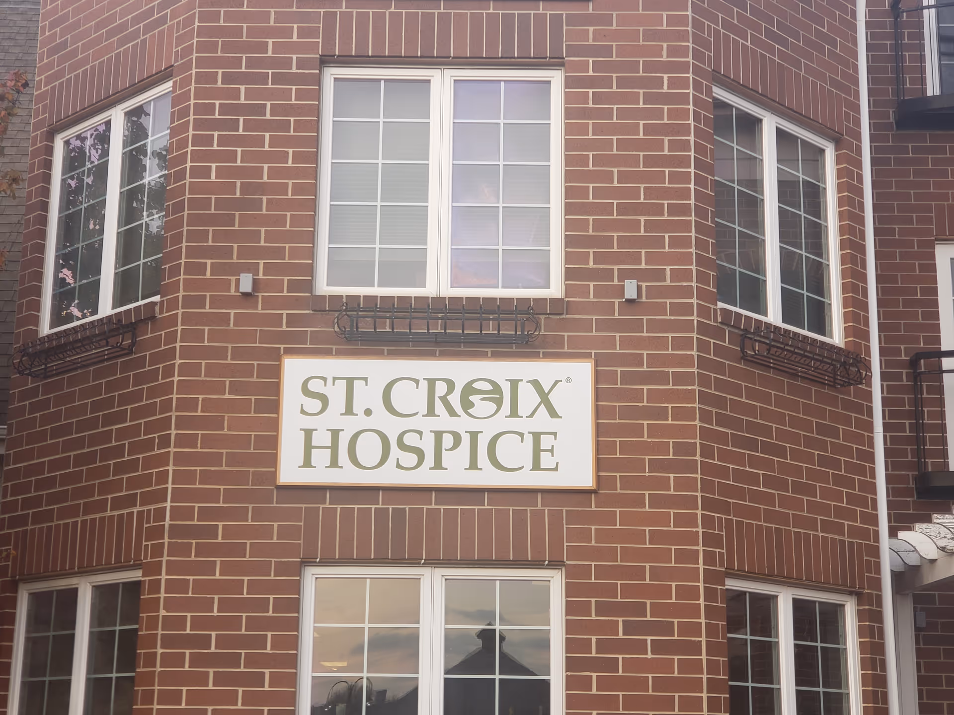 Brick building exterior with St. Croix Hospice sign on facade.