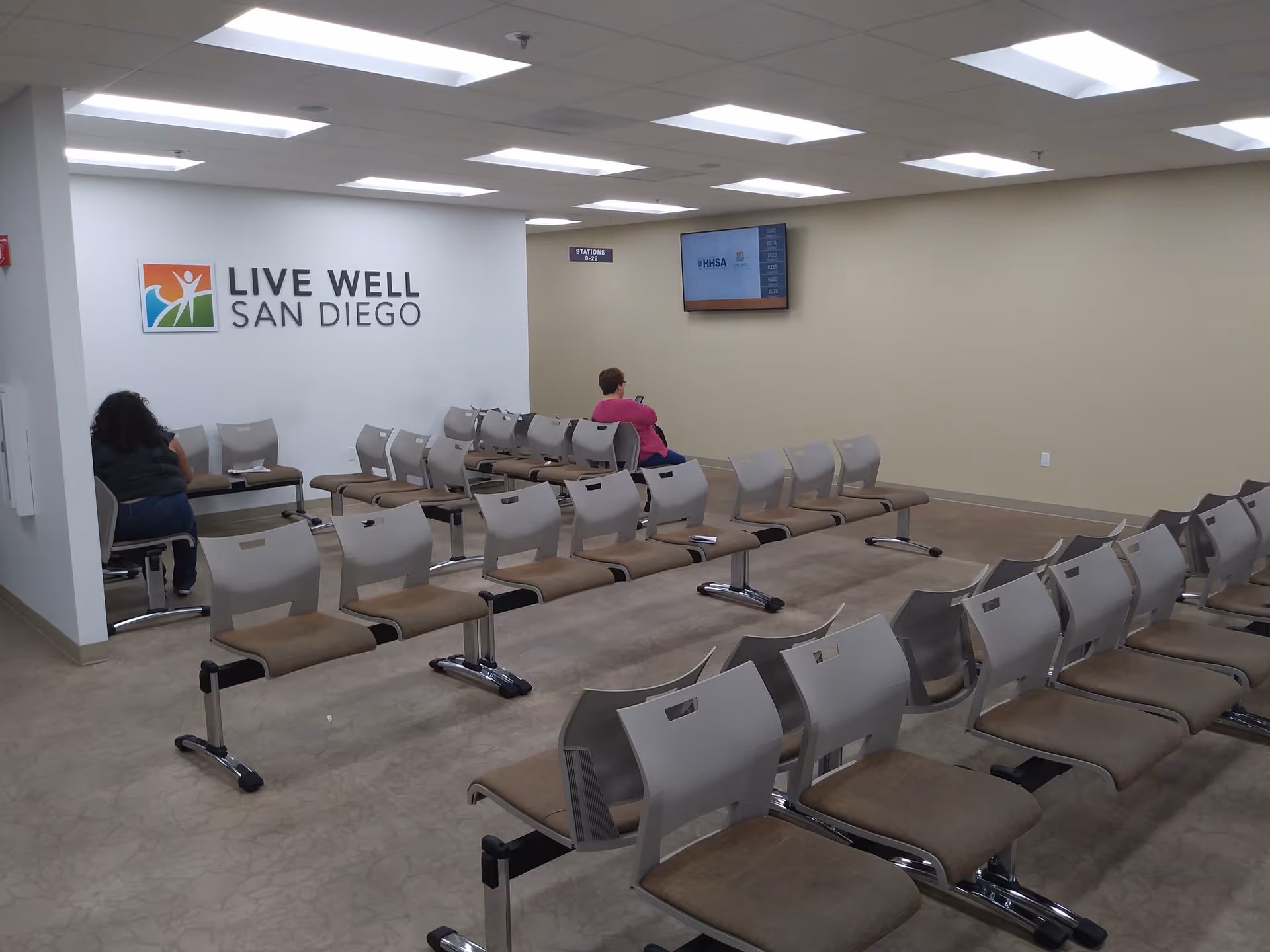 A spacious waiting area with rows of chairs and a Live Well San Diego sign.