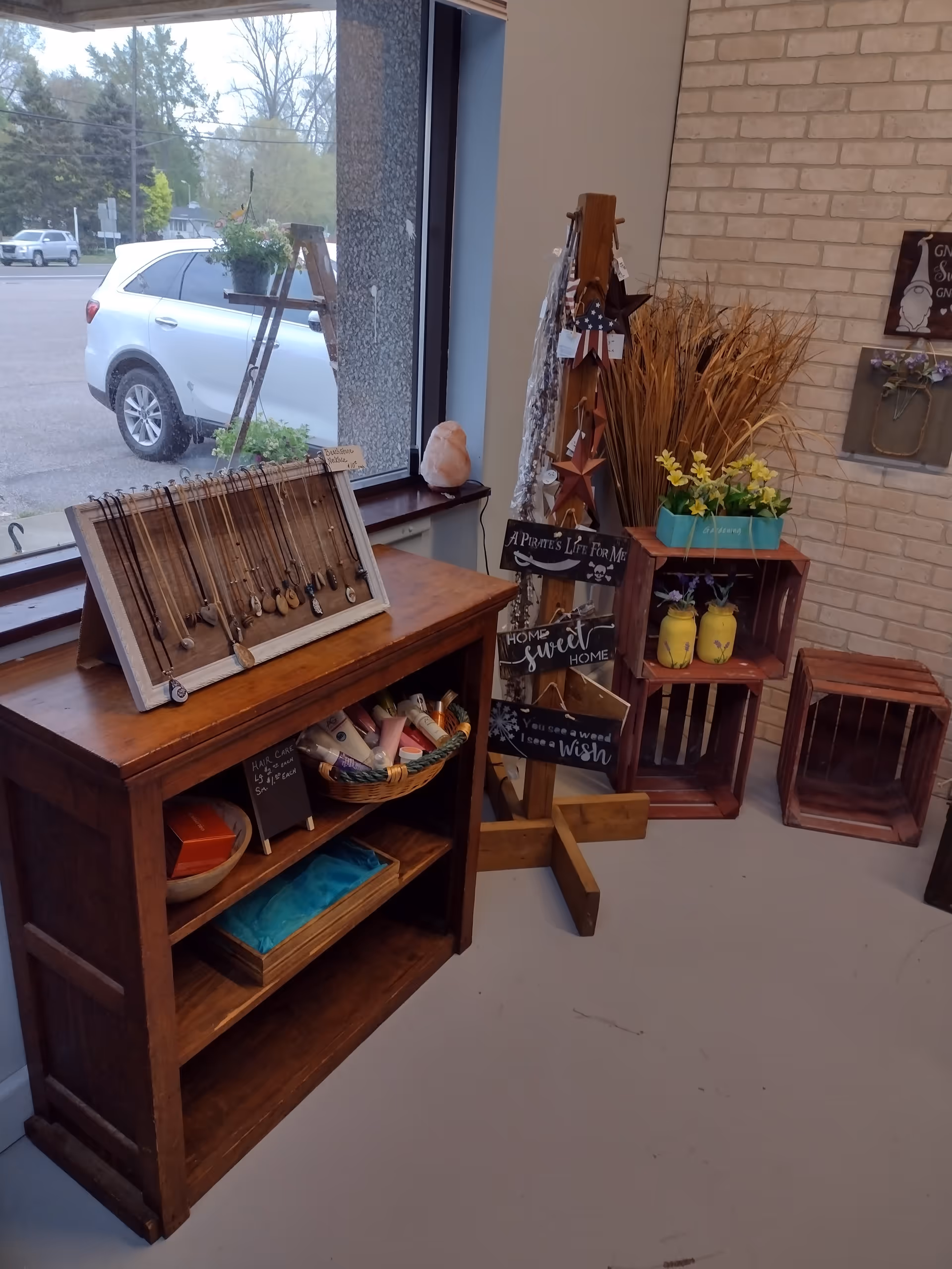 Indoor crafts display with wooden shelves and decorative items near a window.