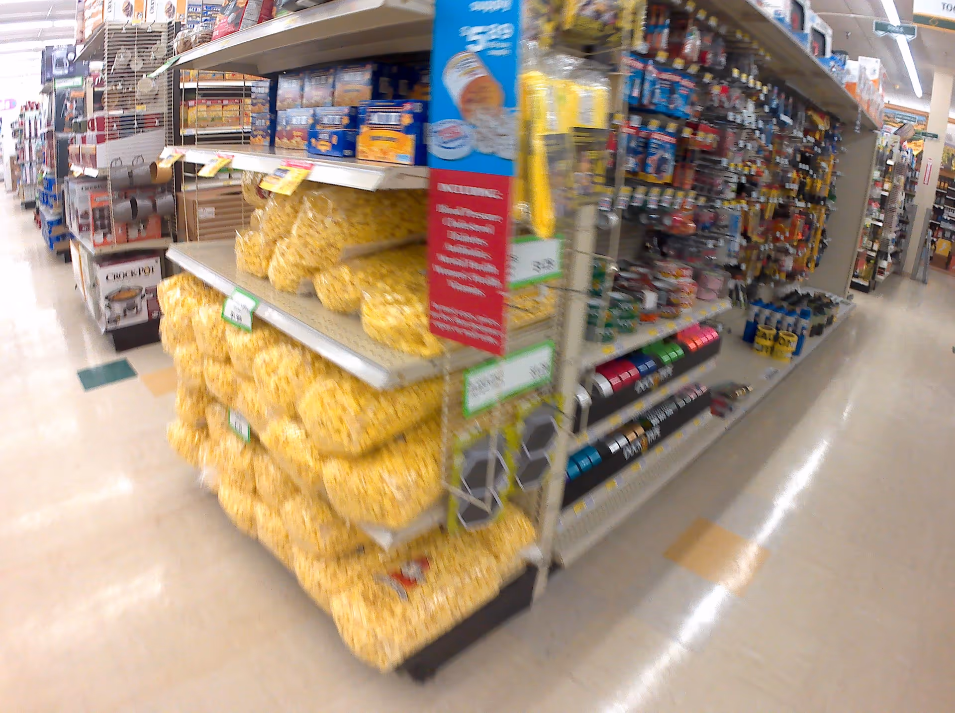 Inside a Discount Drug Mart store aisle with shelves stocked with snacks and supplies