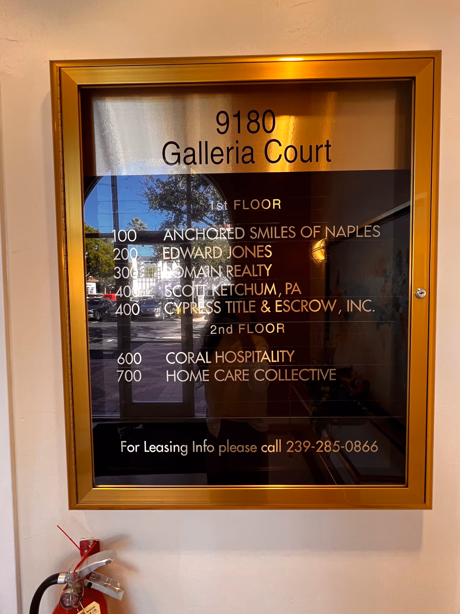 Gold-framed directory plaque in a hallway listing floor numbers and tenants.