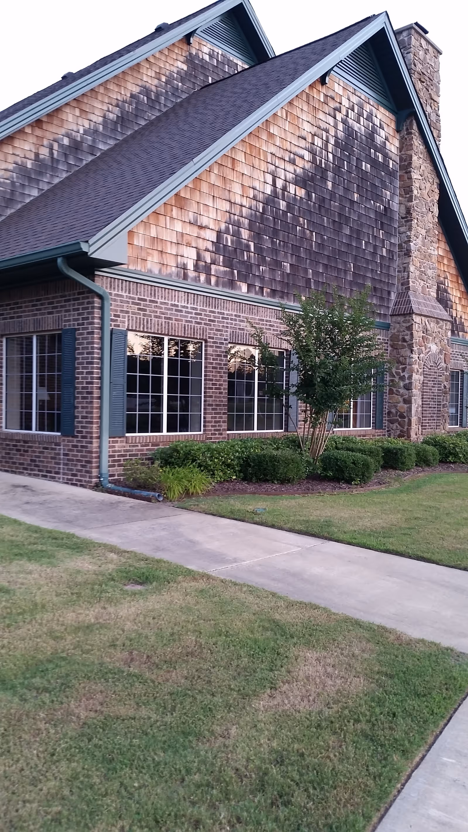Exterior view of a brick hospice facility with large windows and landscaping