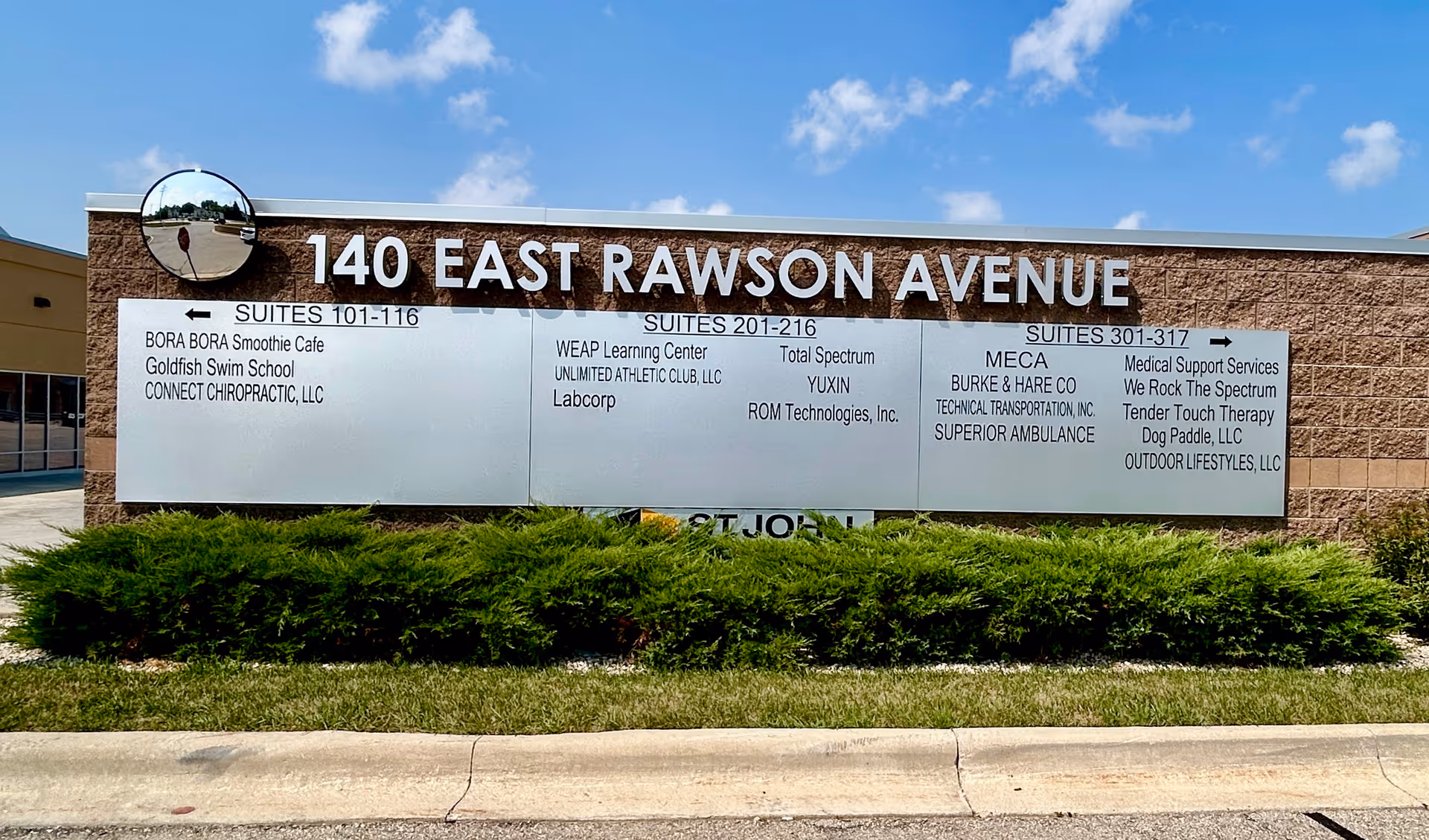 Outdoor building sign reads '140 East Rawson Avenue' with Total Spectrum ABA and suite listings.