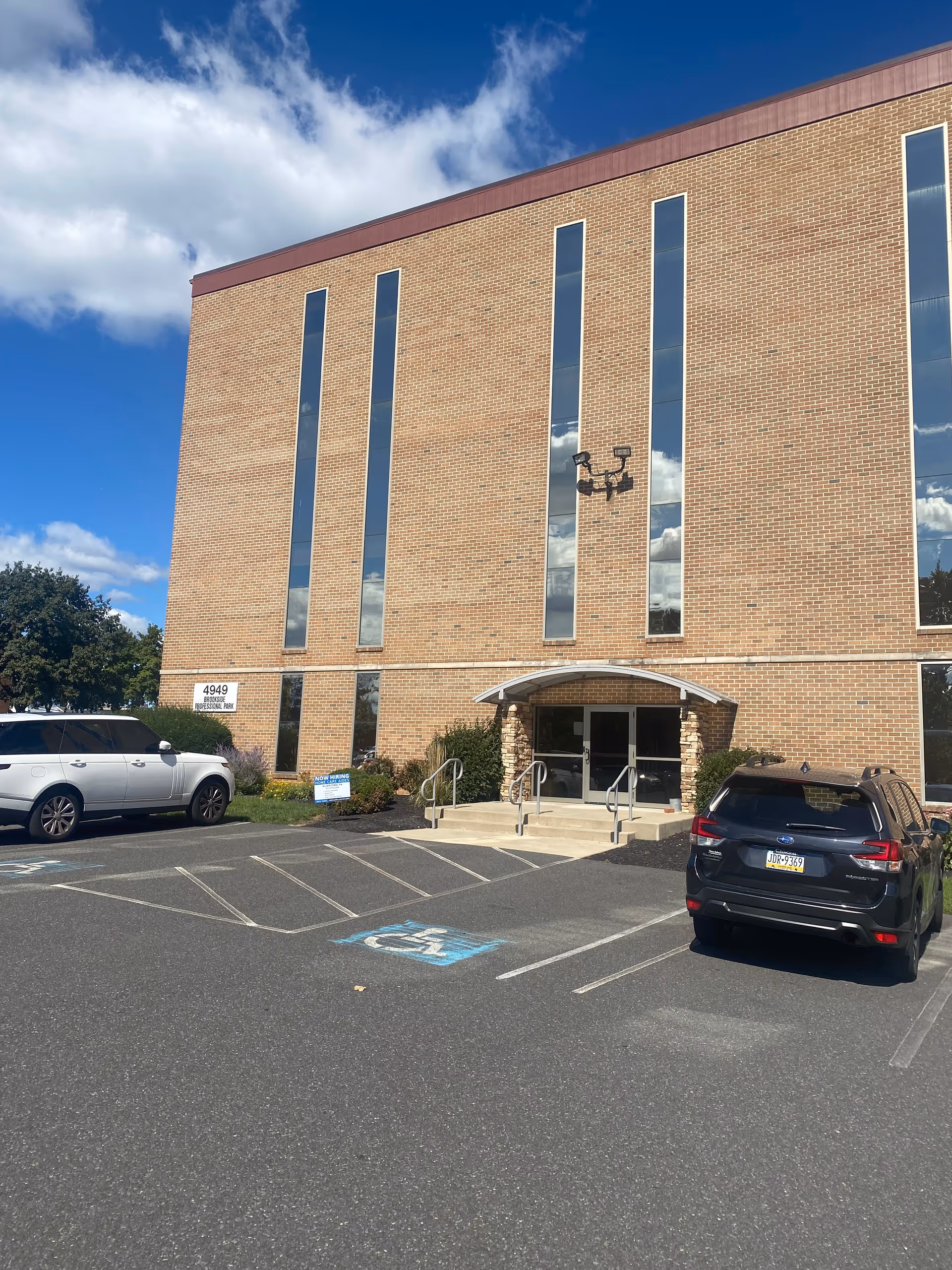 Arcadia Home Care and Staffing building with tall windows, brick exterior, and cars parked in front.