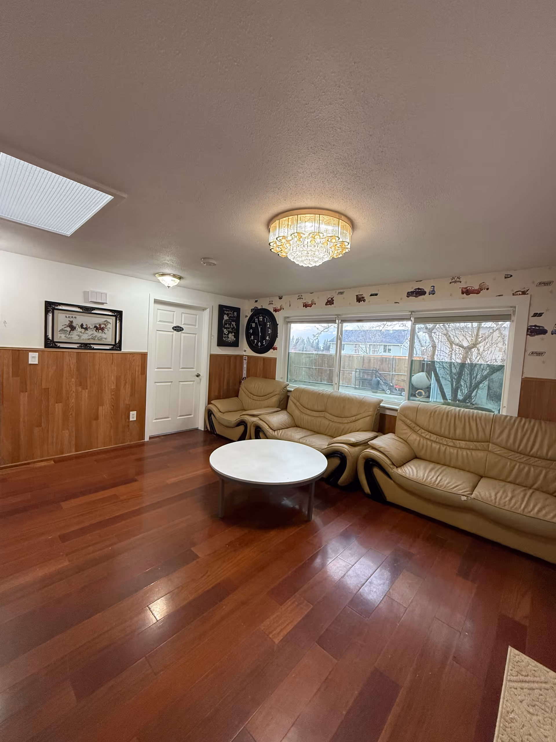 Cozy living room in a senior facility with leather sofas and a round coffee table.