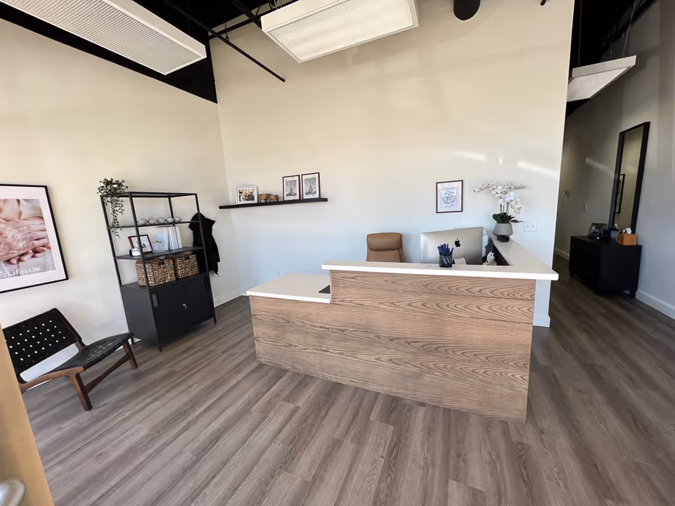Reception desk with wood panels in a bright, minimalist lobby.